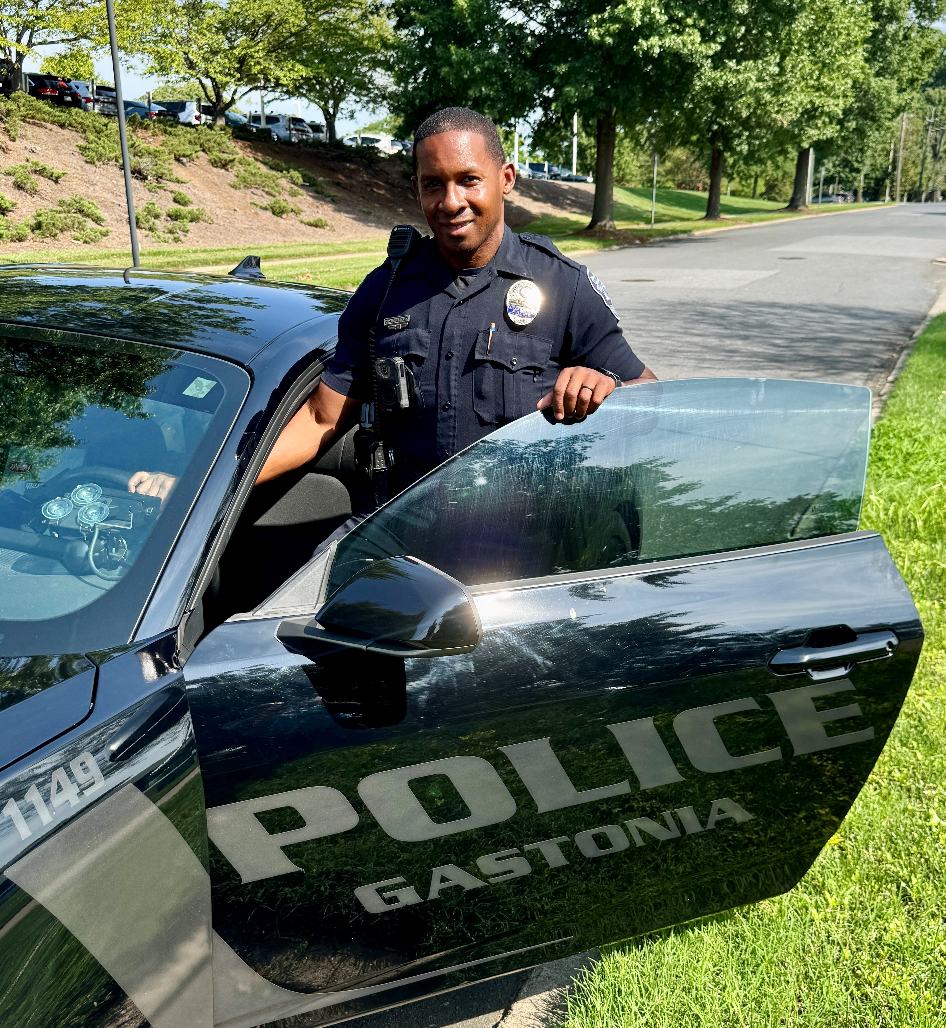 photo of police cadet standing next to the car